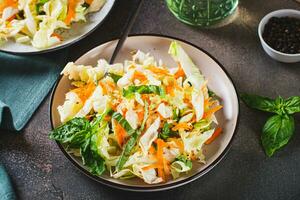 Salad cole slaw with fresh cabbage, carrots and basil on a plate photo