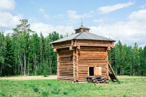 An ancient wooden prison in a forest glade in Siberia. Historical life photo