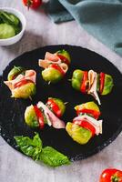 Appetizing sliders with vegetables and ham on a slate board vertical view photo