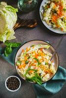 Salad cole slaw with fresh cabbage, carrots and basil on a plate top and vertical view photo
