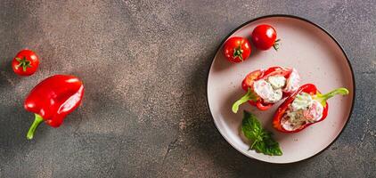 Stuffed peppers with fresh vegetable salad with yogurt on a plate top view web banner photo