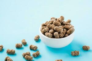 Rye bran in a bowl and on a table on a blue background. Diet and cleansing the body with fiber photo