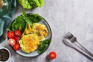 Young cabbage steaks, tomatoes and basil on a plate top view photo