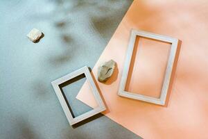 Modern abstract life style background cardboard, blank photo frames and stones in soft shadows from the leaves. Top view. Place for text