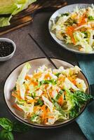 Salad cole slaw with fresh cabbage, carrots and basil on a plate vertical view photo