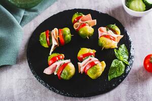 Appetizing sliders with vegetables and ham on a slate board photo