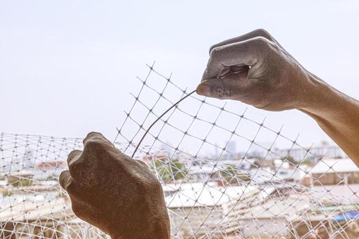 technician worker man install plastic net with wire for protect pigeon bird in balcony apartment. Professional service man setup netting birds for clean and hygiene. photo