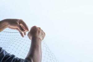 technician worker man install plastic net for protect pigeon bird in balcony apartment. Professional service man setup netting birds for clean and hygiene. Isolated on blue sky background photo