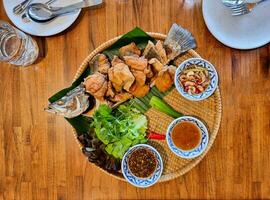 snapper salt crusted grilled fish with spicy and sweet sauce plus white vegetable in big circle plate photo