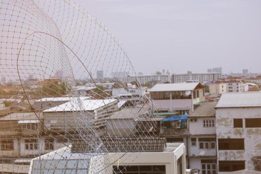 Install plastic net for protect pigeon bird in balcony apartment. Professional service man setup netting birds for clean and hygiene. Isolated on blue sky and high building background photo