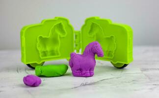 Different color play dough with molds on wooden table. photo