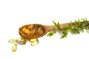 Omega-3 pills on a spoon on a white background photo