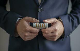 Us dollar bill. Business man hand holding american money, cash. Hundred dollars background. photo