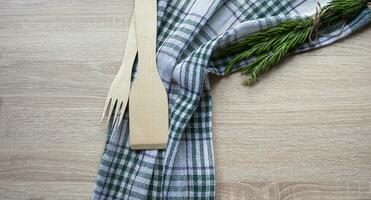 Wooden kitchen utensils on a wooden background. Handmade spoon. Pusher, spatula and spoon made of wood photo