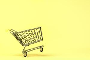 Empty shopping cart with yellow background, 3d rendering. photo