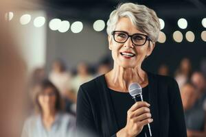 Mature businesswoman speaker speaking to young people. Senior woman in glasses teaching audience or training seminar. Female business leader talking or meeting. Happy retired woman. Generative AI. photo