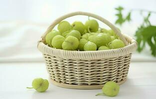 Green gooseberry in a basket on a white round wooden table, Beautiful white background. photo