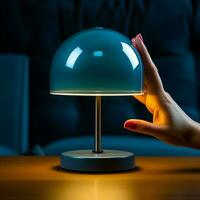 Faceless person turning on with her finger creative table lamp with dark glass dome on in blue room in evening. photo