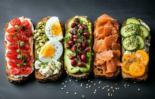 Superfood protein toast with delicious toppings on top avocado, salmon, eggs, vegetables, tomatoes, herbs, and cream cheese on a marble surface. Long wide banner with copy space. photo