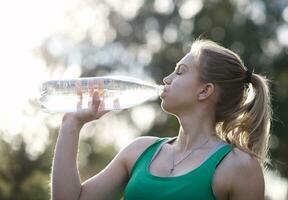 joven mujer Bebiendo agua después aptitud foto