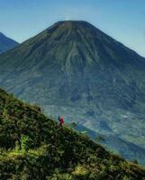 Serene Horizon a Natural Adventure in the Mountain Wilderness Tranquil countryside with green hills, majestic mountains, and breathtaking natural beauty. photo