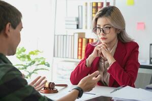 Asian female lawyer or legal advisor signing a contract The contract with the client on the desk in the law firm will guide the client as a legal counsel. photo