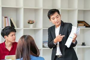 Asian business team consists of marketing staff. accountant and financial officer Help each other analyze company profits using tablets. calculator Laptop computers, graph paper, and corporate pens. photo