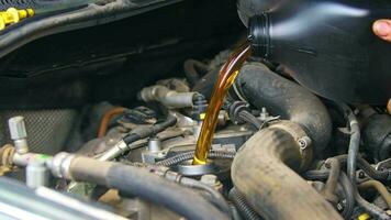 mecánico de servicio de mantenimiento de automóviles que vierte nuevo lubricante de aceite en el motor del automóvil video