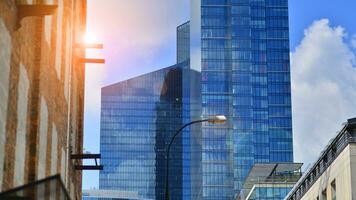 Structural glass wall reflecting blue sky. Abstract modern architecture fragment. Glass building with transparent facade of the building and blue sky. Contemporary architectural background. photo