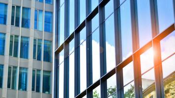 Structural glass wall reflecting blue sky. Abstract modern architecture fragment. Glass building with transparent facade of the building and blue sky. Contemporary architectural background. photo