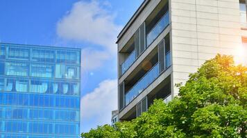 Modern residential building with new apartments in a green residential area. Eco architecture. Green tree and new apartment building. The harmony of nature and modernity. photo