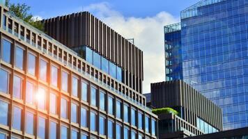 Glass modern building with blue sky background. View and architecture details. Urban abstract - windows of glass office building in  sunlight day. photo