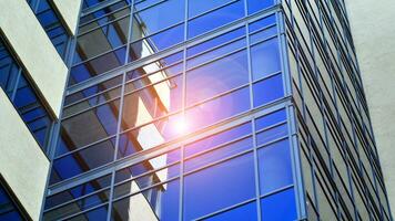 Glass modern building with blue sky background. View and architecture details. Urban abstract - windows of glass office building in  sunlight day. photo