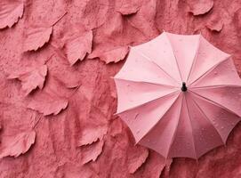 Pink background with autumn leaves and umbrella photo