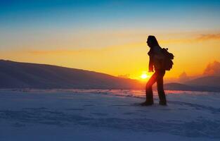 Woman traveler hiking in winter mountains photo