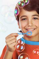 Happy boy blowing bubbles photo