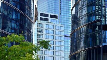 Modern office building with glass facade on a clear sky background. Transparent glass wall of office building. photo