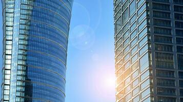 Modern office building with glass facade on a clear sky background. Transparent glass wall of office building. photo