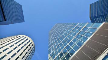 Modern office building with glass facade on a clear sky background. Transparent glass wall of office building. photo