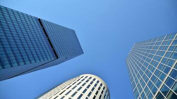 Modern office building with glass facade on a clear sky background. Transparent glass wall of office building. photo