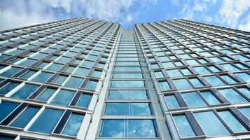 Abstract fragment of contemporary architecture, walls made of glass and concrete. Abstract closeup of the glass-clad facade of a modern building covered in reflective plate glass. photo