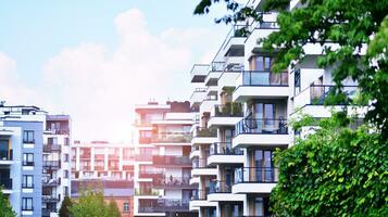 Modern residential building with new apartments in a green residential area. Eco architecture. Green tree and new apartment building. The harmony of nature and modernity. photo