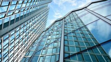 Abstract fragment of contemporary architecture, walls made of glass and concrete. Abstract closeup of the glass-clad facade of a modern building covered in reflective plate glass. photo