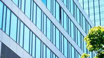 Eco architecture. Details of facade glass and aluminum panels on  building. Green tree and modern office building. The harmony of nature and modernity. photo