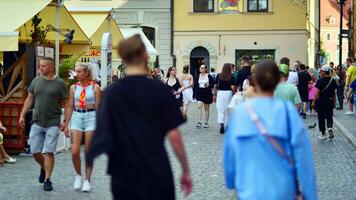 varsovia, Polonia. 29 julio 2023. multitud de personas caminando en un calle. un multitud Moviente en contra un antecedentes de un urbano antiguo ciudad paisaje. foto