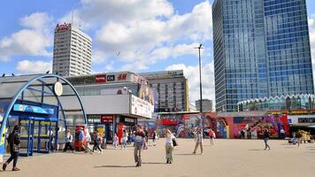 Warsaw, Poland. 9 August 2023. Crowd of people on Patelnia square.The colloquial name of the square in centrum Warsaw. View of a city street with residents, tourists and buildings. photo