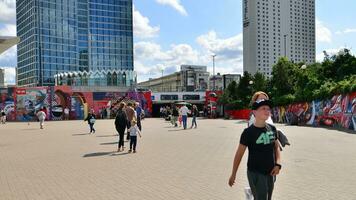 Warsaw, Poland. 9 August 2023. Crowd of people on Patelnia square.The colloquial name of the square in centrum Warsaw. View of a city street with residents, tourists and buildings. photo