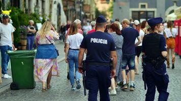 Warsaw, Poland. 29 July 2023. Crowd of people walking on a street. Police patrol the streets. photo