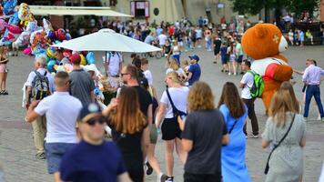 Warsaw, Poland. 29 July 2023. Crowd of people walking on a street. A crowd moving against a background of an urban old city landscape. photo