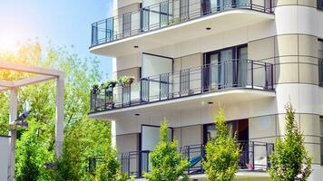 Modern residential building with new apartments in a green residential area. Eco architecture. Green tree and new apartment building. The harmony of nature and modernity. photo